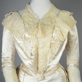Wedding dress, cream silk satin and lace with long sleeves and a train, c. 1905, detail of bodice front