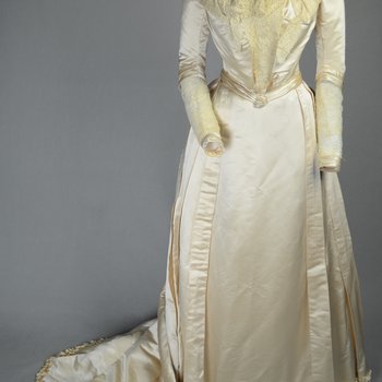 Wedding dress, cream silk satin and lace with long sleeves and a train, c. 1905, front view