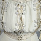 Wedding dress, pale green silk crepe with silver satin, pont d’esprit, and lace, with matching gray shoes with steel-cut beads, 1907, detail of bodice