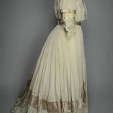 Wedding dress, pale green silk crepe with silver satin, pont d’esprit, and lace, with matching gray shoes with steel-cut beads, 1907, side view