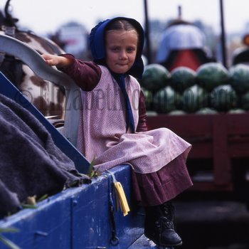 Amish girl on edge of wagon