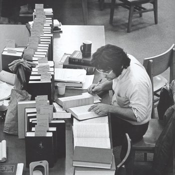 Male student studies at table in library.