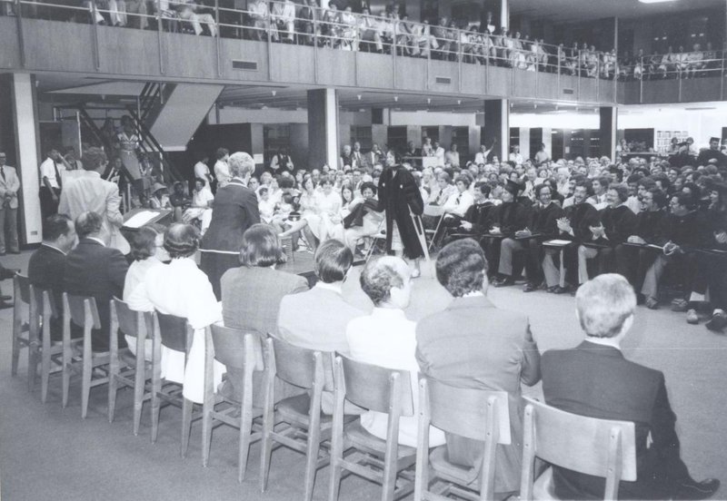 Student on crutches approaches front of library to receive her diploma from Walter Dellinger and Charlie Howell. 1970_163