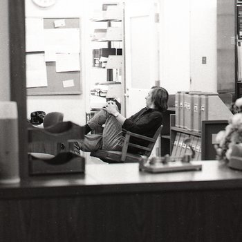 A man gets comfortable behind the circulation desk in the law library.