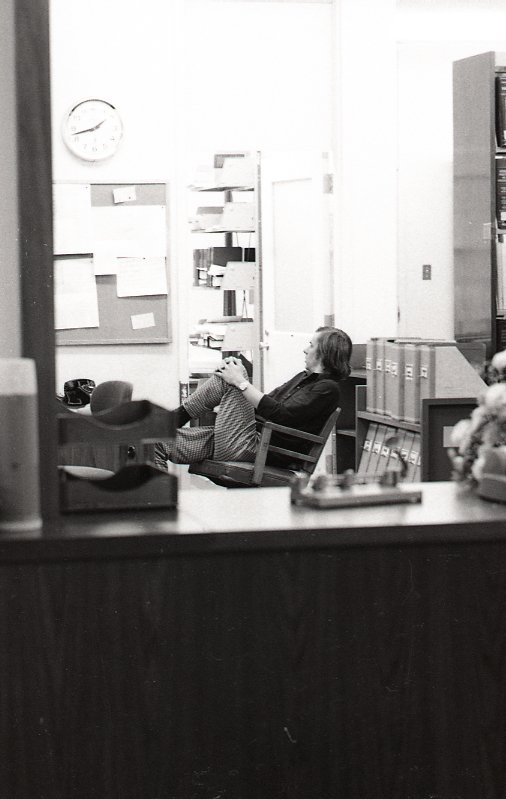 A man gets comfortable behind the circulation desk in the law library.