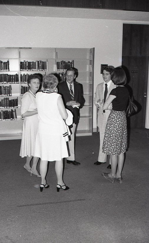 A group of men and women at an event in the library reading room.  Photo no. 1970_554.