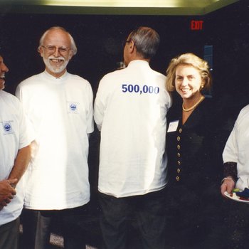 Rufty's son, Richard Danner, Professor Andrew Kaufman, Dean Pamela Gann, and woman celebrate acquiring 500,000th book for the library collection.