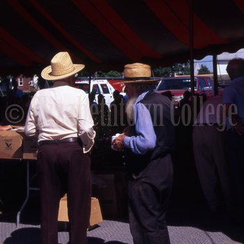Amish and non-Amish men talk at mud sale