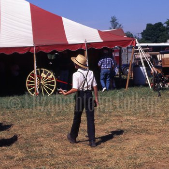 Amish boy standing in front of tent
