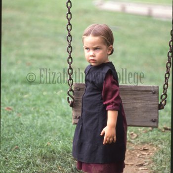 Amish girl holding swing