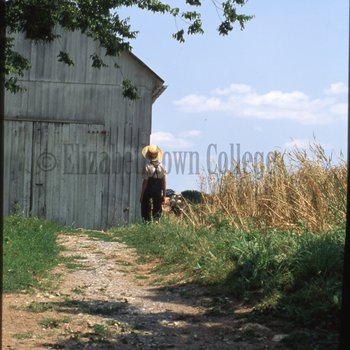 Boy walks toward barn