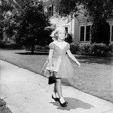 Young girl walking on sidewalk