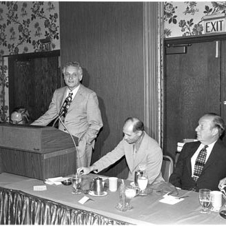 Jean Cowdrick and Lawrence K. Roos Being Inducted into UMSL Chapter of Beta Gamma Sigma, with Arnold Grobman at Podium, 2722