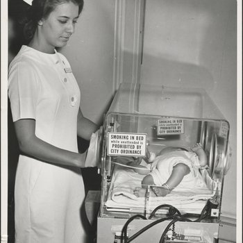 Nurse Checking on Infant in Incubator