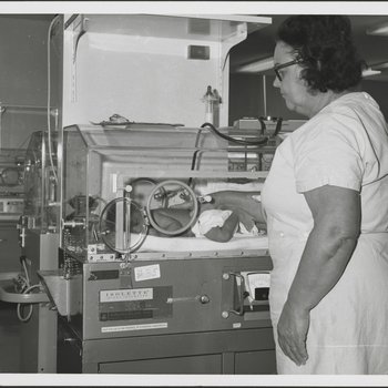 Nurse Checking Infant in Incubator