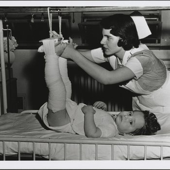 Nurse Adjusting Patient's Legs in Traction