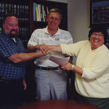 Steve Watkins, Peter Smith, and Diane Cordero de Noriega Shaking hands