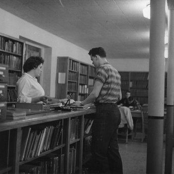 [Student at the circulation desk of Emmanuel Missionary College library]
