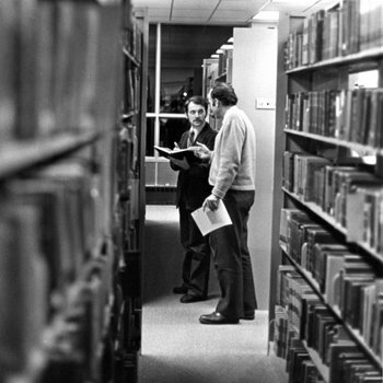 [Andrew Levay and friend in James White Library stacks]