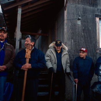 Members of the Tlingit Tribe pause for comments in front of the Bear Clan House at Angoon, Alaska, November 1, 2003