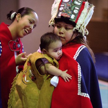 A Tlingit baby is admired during a welcoming ceremony for a recently returned Bear Clan Totem in Angoon, Alaska, November 1, 2003