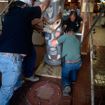 University of Northern Colorado facilities workers carefully lower a Tlingit Bear Clan Totem from its mount in the University Center, October 20, 2003 2