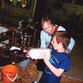 Roz with grandson feeding cow