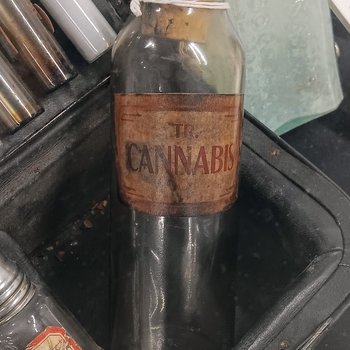 Glass bottle, stained brown, with cork and label “Tr. Cannabis”