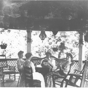 Margaret Mitchell McCloud and friends playing cards on the Mitchell cottage porch.