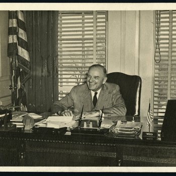 Jim Nance McCord seated at Governor's desk