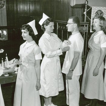 Nursing program graduation showing first male nurses, 1963