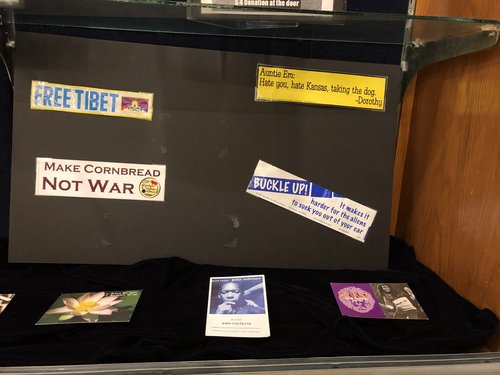 four bumper stickers, clockwise: 1) Free Tibet, 2) Auntie Em: Hate you, hate Kansas, taking the dog -- Dorothy, 3) Buckle up! It makes it harder for the aliens to suck you out of your car, 4) Make cornbread not war (Southern Foodways Alliance)