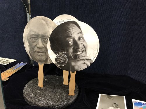 paper hand fans, each featuring a prominent blues artist from the roster of Fat Possum Records: R. L. Burnside and Junior Kimbrough