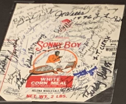 An empty 2-pound bag of Sonny Boy White Corn Meal is covered by signatured from blues musicians.