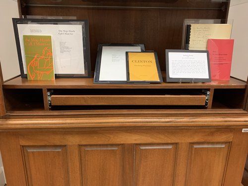 display of publications by Sterling D. Plumpp: the Mojo Hands Call I Must Go, Clinton, and Blues the Story Always Untold. exhibit card about Plumpp in photo has been transcribed on the page.