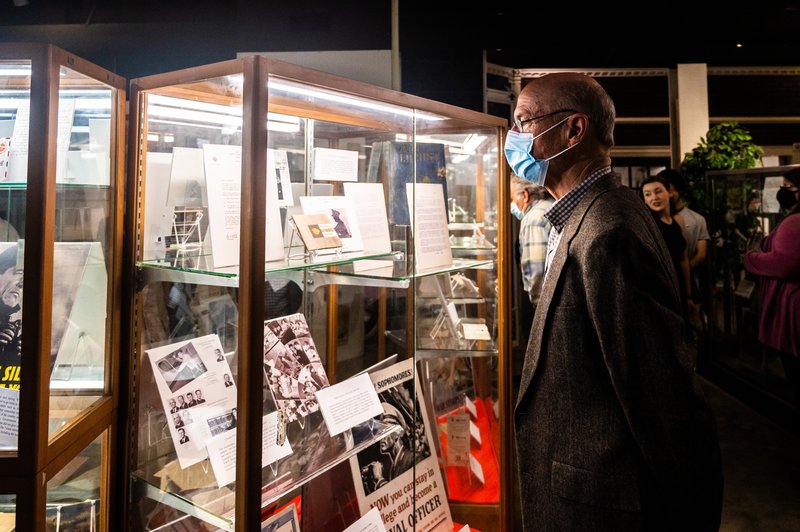 A reception guest stops to take in the Education display items