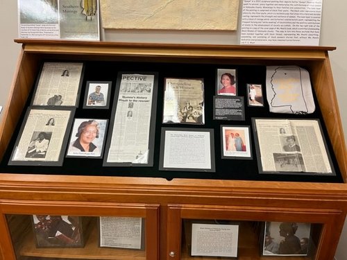 display case containing newspaper columns of Dottie Quaye Chapman Reed, and associated photographs