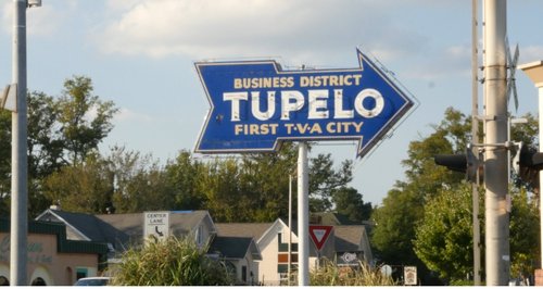 A vintage neon sign points toward Tupelo&#x27;s business district