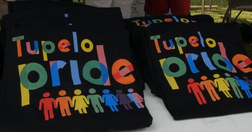 For sale: Tupelo Pride t-shirts, with text and human shapes in a rainbow typeface