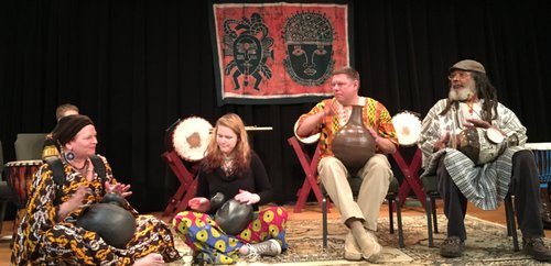 Two men and two women play West African udu drums.