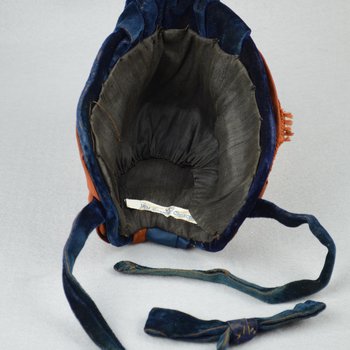 Bonnet, black straw capote trimmed with blue velvet, silk ribbons in blue and dark orange, and artificial flowers, 1880s, interior view